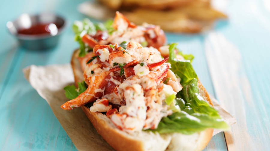 lobster roll on colorful retro painted wooden planks shot close up